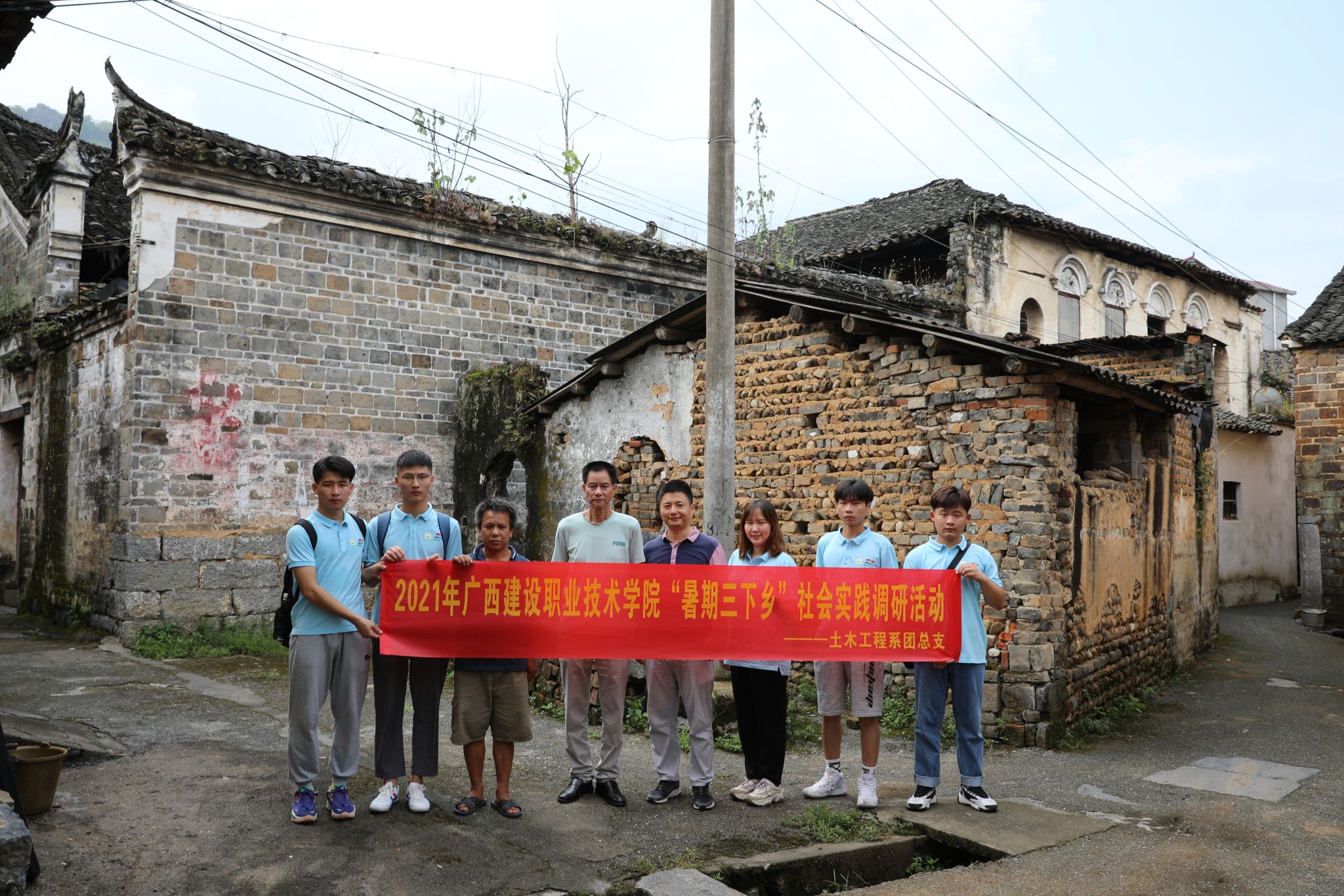 實踐團成員在歷史民居前與石腳村村民合影